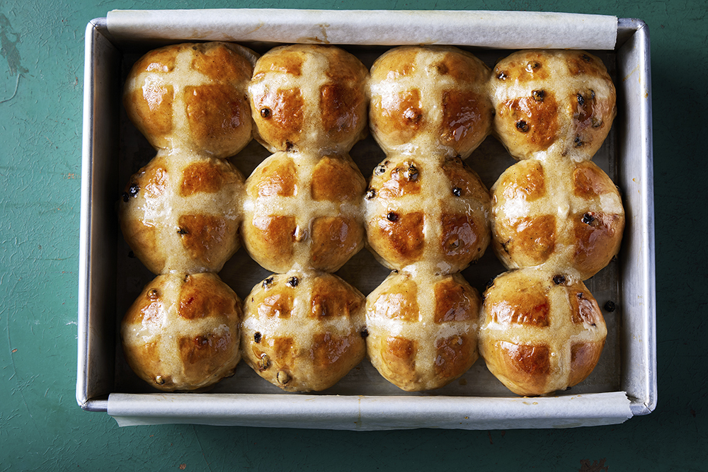 This image released by Milk Street shows a recipe for hot cross buns studded with bourbon-plumped currants. (Milk Street via AP)