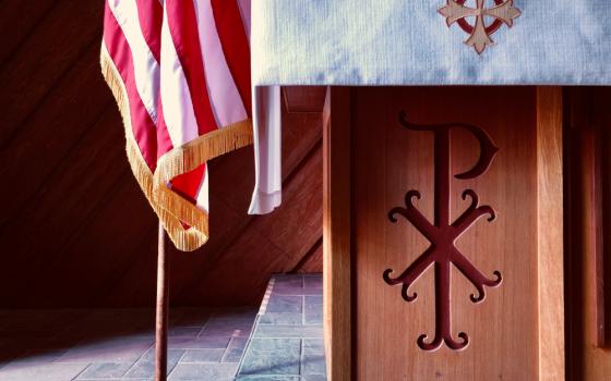 Brown wooden cross with flag of USA on top